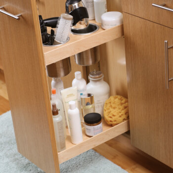 Organized pull-out storage for beauty products, curling irons, hair dryers, etc. in the bathroom with a Vanity Grooming Cabinet accessory.